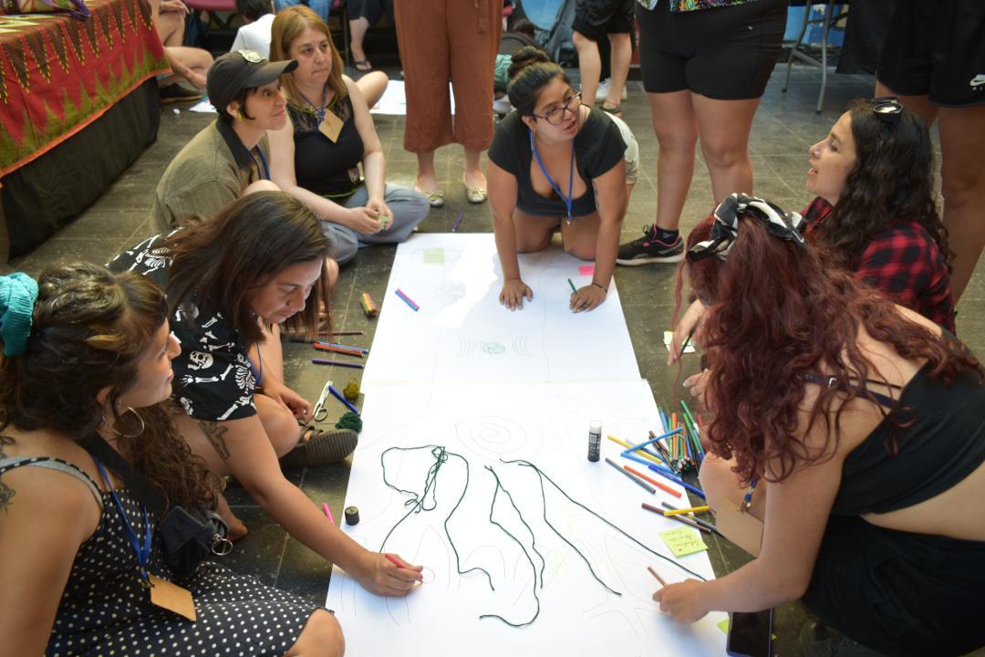 Activistas en un encuentro nacional, escribiendo en una cartulina