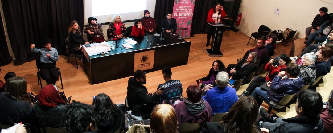 La imagen muestra una visión panorámica del conversatorio "El orgullo de transformar el mundo".